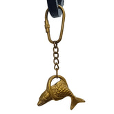 A gold-colored brass key ring in the shape of a fish, attached to a black keychain.